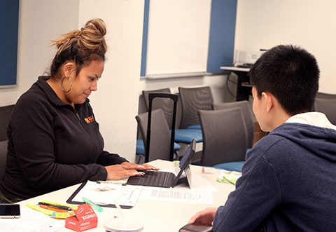 Photo of CalFresh worker helping students register for CalFresh.