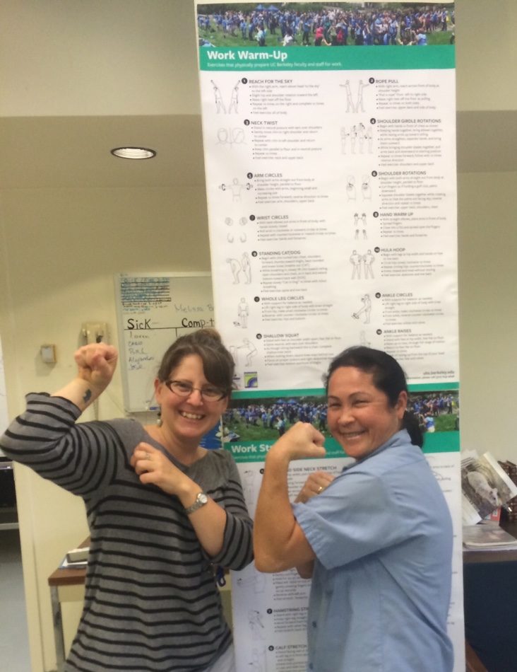 Two Office of Laboratory Animal Care employees flexing after they complete the Stretch and Flex program.