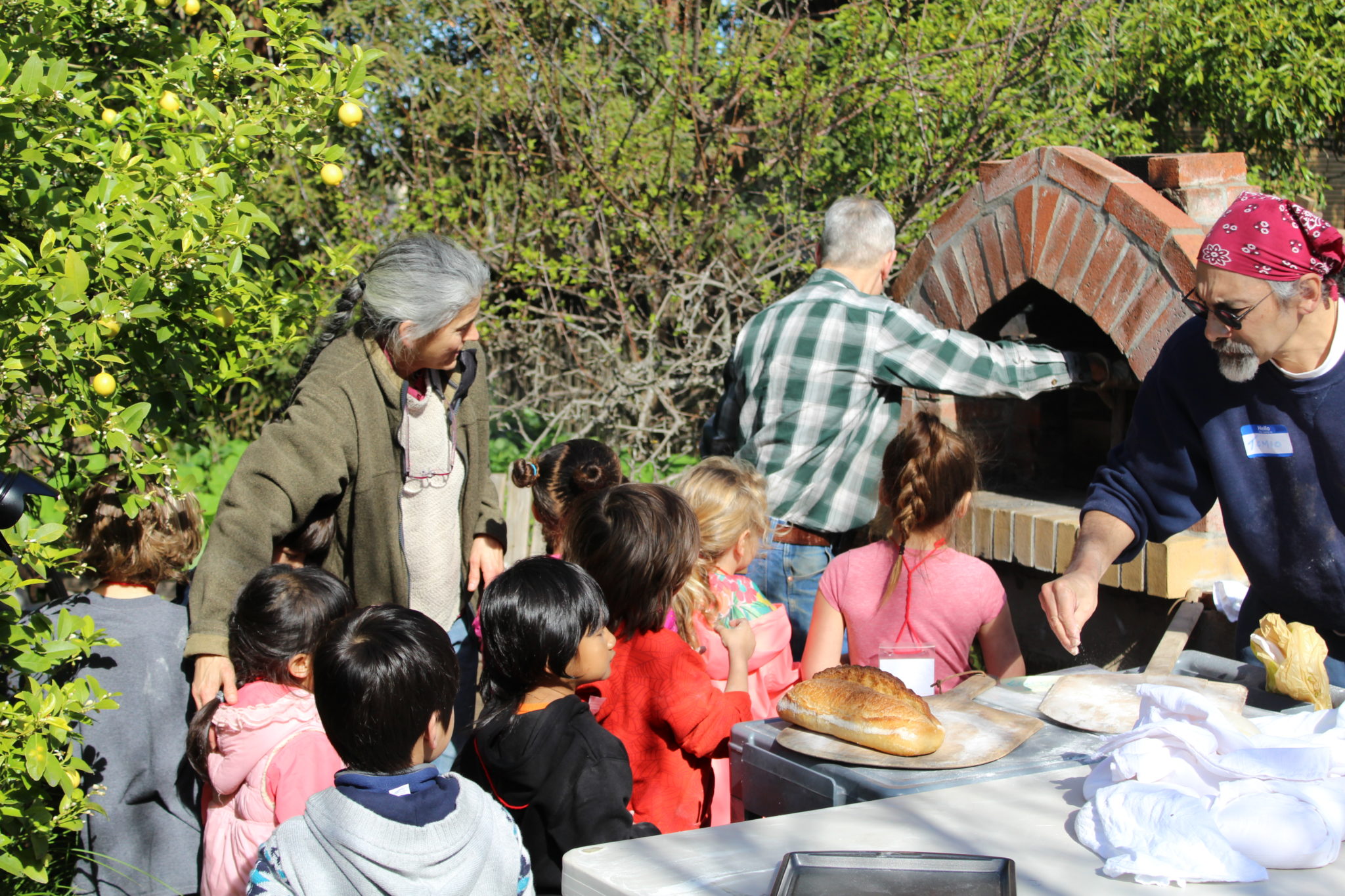 Children look on and learn about the baking process for bread.