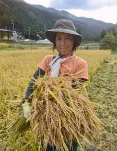 Farmer Nami Yamamoto carries a wheat harvest from the farm.