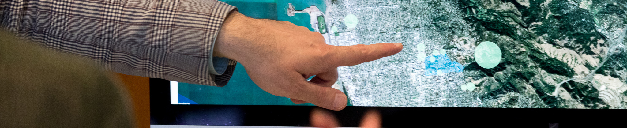Finger pointing at map
