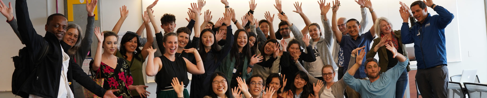 Participants of Hackathon with their hands in the air.